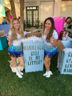 two girls dressed in cheerleader outfits holding up boxes that say mmmm, rlyl is my little?