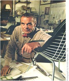 a man sitting at a desk with scissors in his hand