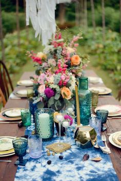 the table is set with blue and pink flowers