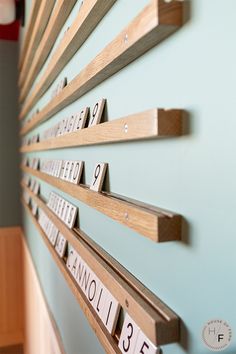 a wall mounted calendar on the side of a blue wall with wooden letters and numbers