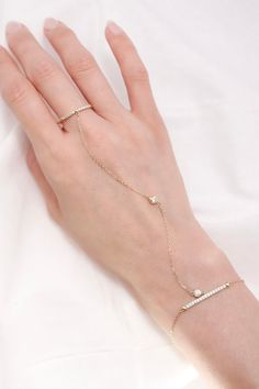 ITEM INFO Enhance your style with the striking 14K Solid Gold Ring Hand Chain Bracelet, a sophisticated accessory that blends modern design with timeless elegance. Crafted from radiant 14K solid gold, this unique bracelet features a delicate chain that gracefully connects a sleek gold ring to the bracelet, creating a seamless look that adorns both your wrist and finger. This hand chain bracelet is the perfect statement piece for those who love to combine bold fashion with classic luxury. Whether worn alone or layered with other accessories, this bracelet offers a chic and refined addition to any jewelry collection. Key Features: Material: Premium 14K solid gold for a luxurious, lasting shine Design: A unique hand chain design that connects a ring to the bracelet for a contemporary and eleg Finger Ring Bracelet, Hand Chain Bracelet, Moon Studs, Solid Gold Ring, Ring Hand, Hand Bracelet, Chain Design, Unique Bracelets, Delicate Chain