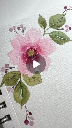 an open notebook with watercolor flowers and leaves painted on the pages, along with a video