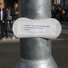 there is a sign on the pole that says imagine if men were disguised with paper as they are with periods