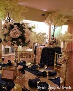 the tables are set with black and gold linens, white flowers, and place settings