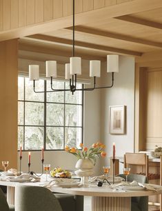 a dining room table with candles and flowers on it