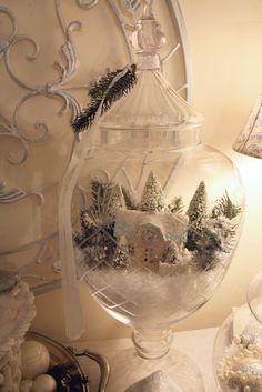 a glass vase filled with snow and christmas decorations