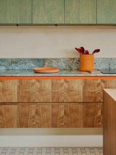 a kitchen with wooden cabinets and blue marble counter tops, along with a yellow basket