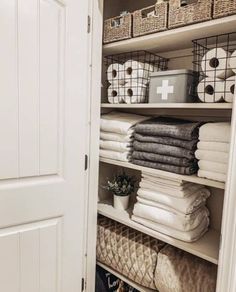 an organized closet with folded towels and baskets