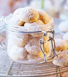 a glass jar filled with powdered sugar covered donuts