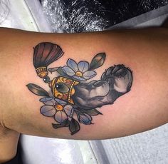 an elephant tattoo with flowers on its arm