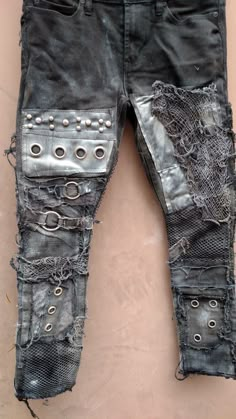 an old pair of black jeans with holes and rivets