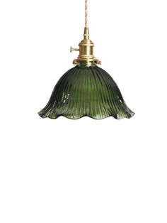 a green glass light hanging from a ceiling