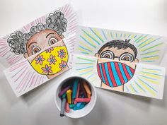 two children's drawings on paper with colored crayons in front of them