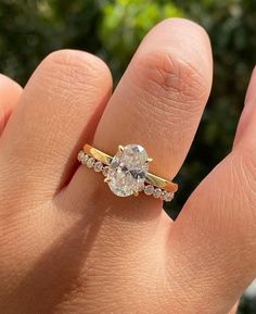 a woman's hand with a yellow and white diamond ring on top of it