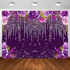 purple roses and stars hanging from the ceiling in front of a wall with beads on it