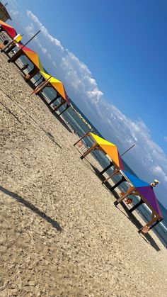 several colorful beach umbrellas lined up on the beach