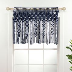 a blue curtain with fringes hanging from it's side in front of a window