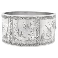 A fine signed, antique English Aesthetic Movement bangle bracelet. In sterling silver. Struck FM (likely for Frederick Marson of Birmingham). With a hinged side and 3 square cartouches with engraved bird scenes. Secured by a hidden box clasp. Simply a wonderful Aesthetic Movement cuff bracelet! Date: Late 19th Century, 1882 Overall Condition: It is in overall good, as-pictured, used estate condition. Condition Details: The bracelet has a slight oval, egg-shaped profile. There are several light creases, dings, and indentions to the surface. Otherwise, there is some light edge wear, some fine and light surface scratches, and other signs of light wear consistent with age. Maker: Attributed to Frederick Marson Marks: Hallmarked for Birmingham / Sterling Silver / 1882 and with a partially legib Victorian Hinged Cuff Bangle Bracelet, Luxury Antique Cuff Bracelet, Luxury Vintage Antique Silver Cuff Bracelet, Luxury Silver Victorian Cuff Bracelet, Luxury Antique Silver Vintage Cuff Bracelet, Antique Aesthetic, Victorian Aesthetic, Hammered Bangles, The Bangles