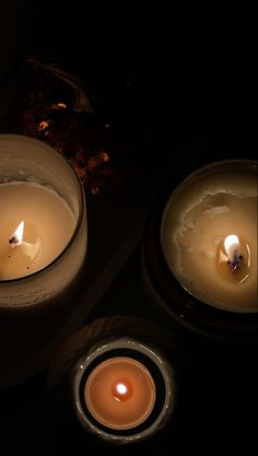 three lit candles sitting next to each other