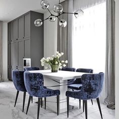 a dining room table with blue chairs around it