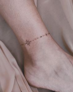 a woman's foot with a small star tattoo on the left side of her ankle