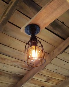 a light that is hanging from the ceiling on a wooden structure with wood planks