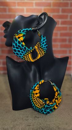 These fabric hoop earrings are lightweight and feature vibrant colors that will compliment your fashion aesthetic. Fabric Hoop Earrings, Africa Jewelry, Moda Afro, African Print Shirt, Unique Earring, African Crafts, Abstract Earrings, Mixed Media Jewelry, African Earrings