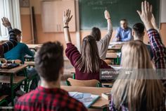 students raising their hands in class at the end of an exam day stock - fotor