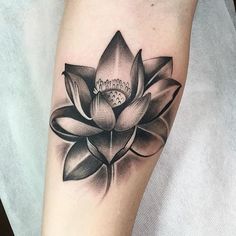 a black and white lotus tattoo on the arm