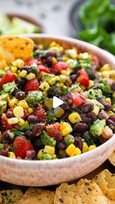 a white bowl filled with black beans and corn salsa next to tortilla chips