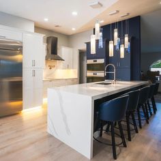 a large kitchen with an island and bar stools