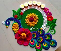 a decorated table with candles on it and flowers in the center, surrounded by beads