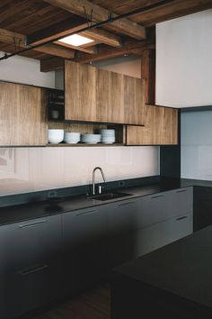 a kitchen with wooden cabinets and black counter tops in an industrial style home or office