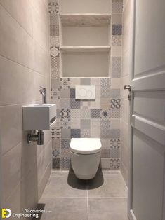 a toilet in a small bathroom with tiled walls