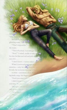 a man and woman laying on top of each other in the grass next to water