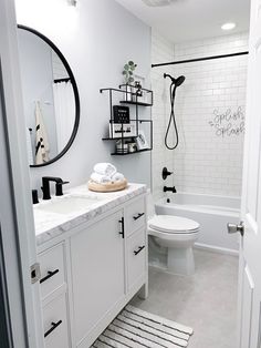 a white bathroom with black and white accessories