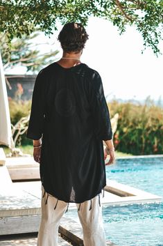 Capri luxury resort kimono black. Our unique hand made kimono in a lightweight cotton fabric that is very comfortable to wear all the way from festivals, rave parties to sunny resort vacations on sophisticated locations. This kimono is made to give a bohemian feeling with its hand broidery patch on the back and fringes hanging from the ends. Its the perfect addition to your outfit. In the pictures we are matching the kimono with our beloved yoga harem pants Moremi. The black creme colours is eas Black Long Sleeve Festival Kaftan, Black Spring Festival Cover-up, Oversized Cover-up With Kimono Sleeves For Festivals, Oversized Festival Cover-up With Kimono Sleeves, Black Beachwear Cover-up For Festival, Oversized Black Beachwear Cover-up, Black Long Sleeve Cover-up For Festivals, Oversized Black Cover-up For Vacation, Black Long Sleeve Festival Cover-up