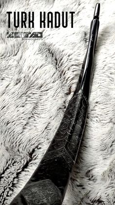 a black pen laying on top of a white fur covered surface with text overlay