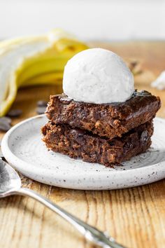 two brownies with ice cream on top are sitting on a plate next to bananas