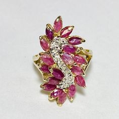 14K Yellow Gold Marquise Cut Ruby Diamond Cocktail Ring Size 9 18 Marquise cut rubies, measuring approx. 5 x 3 mm, 4.50ctw 10 Round brilliant cut diamonds, measuring approx. 1.0 mm, 0.05ctw Approx. top measurements: length 16.0 x width 29.3 x height 11.3 mm Shank measures 2.3-2.1 mm Stamped R 14K (stamp is worn and not clear in photo, we electric tested as 14k gold) Total weight approx. 7.34 g Condition preowned, please see photos for details Ruby Butterfly Ring, Marquise Multi-stone Ruby Ring In Fine Jewelry Style, Marquise Multi-stone Ruby Ring, Fine Jewelry Marquise Ruby Ring With Multi-stone, Marquise Ruby Jewelry With Diamond Accents, Marquise Ruby Jewelry With 17 Jewels, Fine Jewelry Multi-stone Marquise Cut Ruby Ring, Multi-stone Cluster Ruby Ring, Multi-stone Ruby Cluster Ring