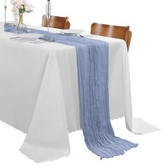 the table is set with white and blue linens