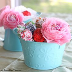 two blue buckets filled with candy and flowers