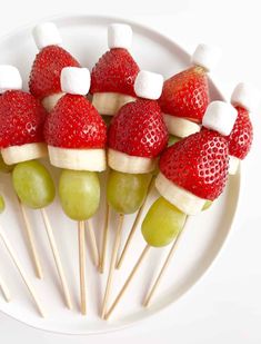 fruit skewers with marshmallows and strawberries are arranged on a plate