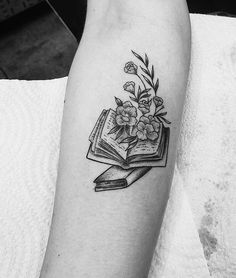 a black and white photo of a book with flowers on it