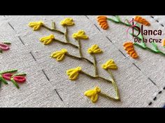 some yellow and red flowers are on a white table cloth with the words flame de la cruz written in spanish