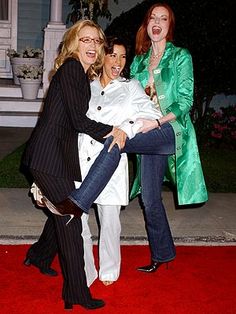 three women are posing on the red carpet at an event with one woman holding her leg up