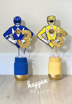 two vases that have some type of decoration on top of them, one is blue and the other is yellow