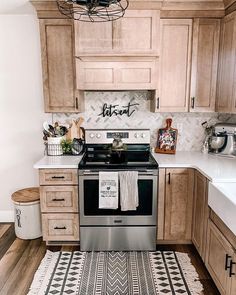 a kitchen with wooden cabinets and white counter tops, black and silver stove top oven