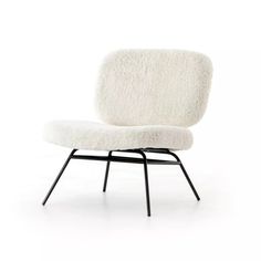 an upholstered chair with black legs and a white sheepskin seat cover on it