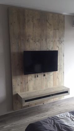 a flat screen tv mounted to the side of a wooden wall